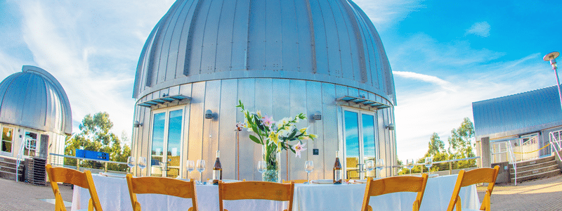 Bright view of all three telescope domes, with tables set up for a wedding at Chabot. 