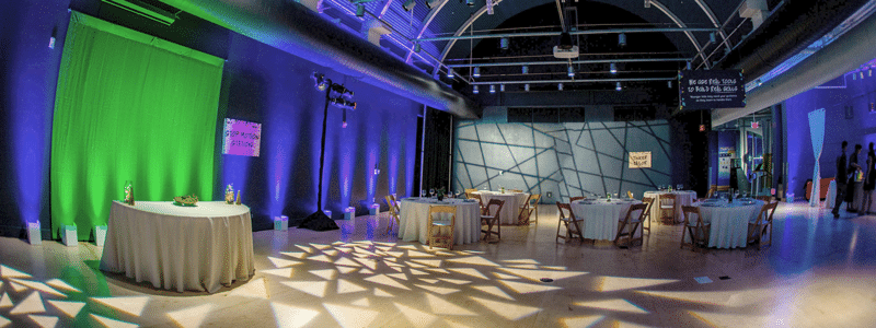 Wedding table set-up in Astronomy Hall with green and purple lighting at the Center. 