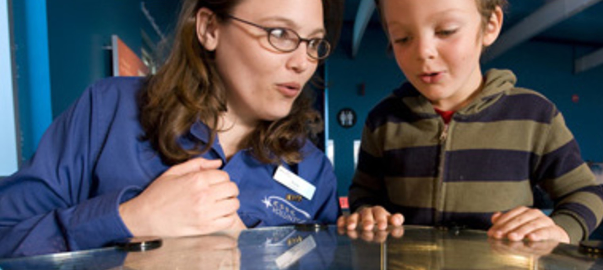 Volunteer and young visitor with expressions of amazement. 