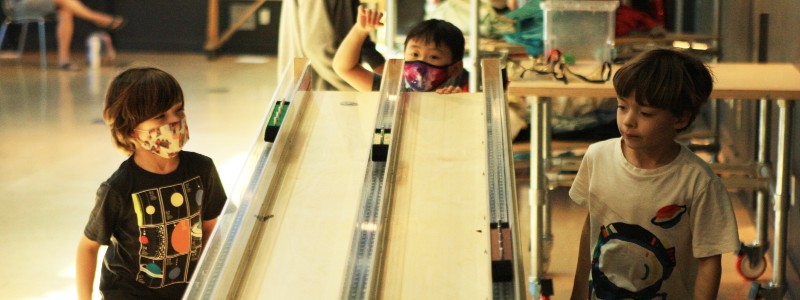 Three young visitors playing in Astronomy Hall. 